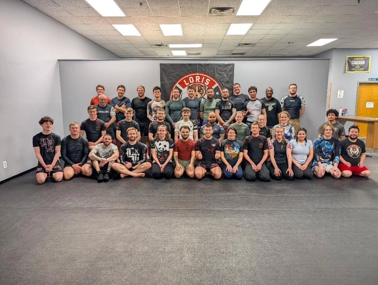 Large group of students and instructors posing on the mat at Loris Brazilian Jiu-Jitsu