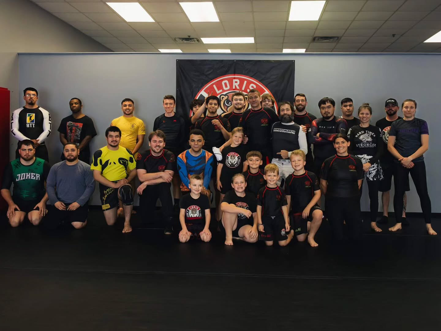 Group of adults and children in training gear at Loris Brazilian Jiu-Jitsu